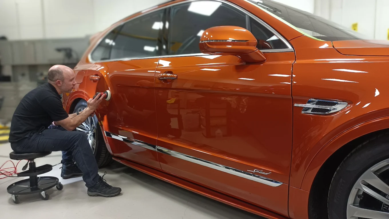 Neil machine polishing a prestige car in his County Durham studio
